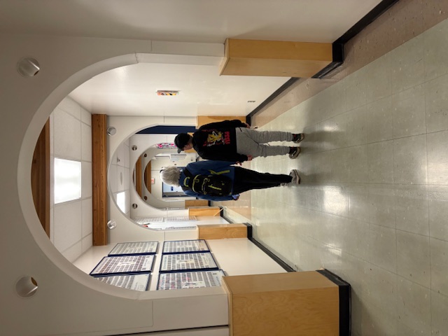 Student and O&M specialist pass under an archway in a long hallway