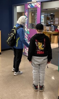 Student with a long cane and O&amp;M specialist discuss entering the library 