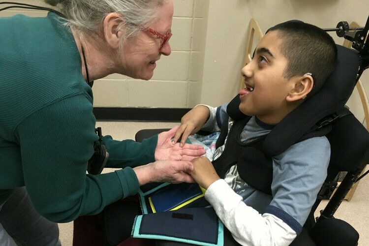 Student and Intervenor looking at one another while holding hands.